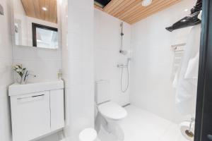 un bagno bianco con doccia e WC di Forenom Serviced Apartments Helsinki Lauttasaari a Helsinki Altre 31 foto