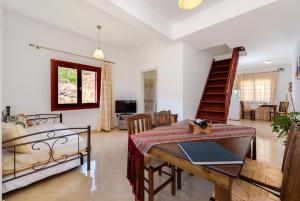 sala de estar con mesa y cama en Aspalathos Suites en Akrotiri