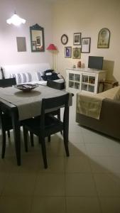 ポルト・サン・パーオロにあるAppartamento Rosasのリビングルーム(テーブル、ソファ付)