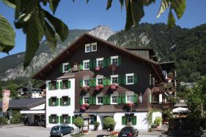 a building with green shuttered windows and a mountain at Relax & Vitalhotel Adler in Schruns