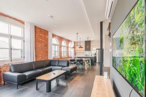 a living room with a couch and a tv at Les Lofts du Trésor - Par Les Lofts Vieux-Québec in Quebec City