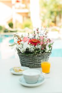 a basket of flowers and a cup of orange juice at Nikoleta Luxury Villa in Limenas