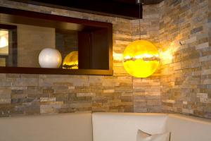a room with a couch and two lights on a brick wall at Glanz & Glory Hotel in Sölden +102 photos