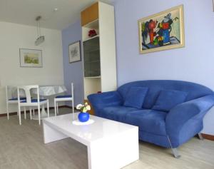 a living room with a blue couch and a table at Appartementhaus im Grün in Bad Bellingen