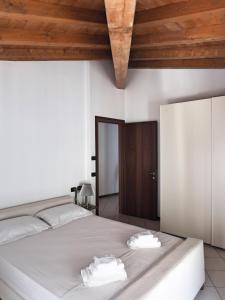 een slaapkamer met een wit bed met twee handdoeken erop bij Appartamenti al Golfo in Salò