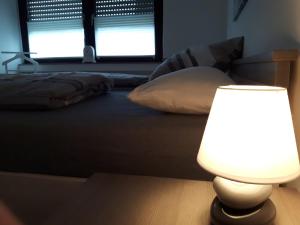 a bedroom with a bed with a lamp on the floor at Charmant und stilvoll in Kaarst