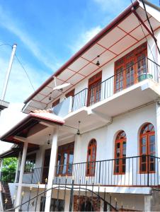 a white house with red windows at Ajanthas' Homestay in Kandy