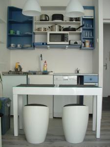 a kitchen with a white table and white stools at Nice Apartments Prague in Prague