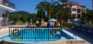 a swimming pool with chairs and umbrellas at a resort at Litsa Studios in Alikanas