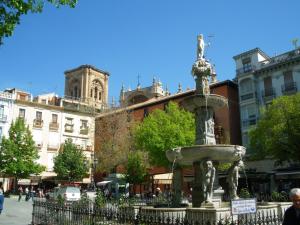 a fountain in the middle of a city with buildings at Apartments Zarate in Granada
