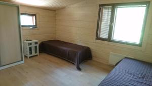 une chambre avec un lit dans une chambre avec une fenêtre dans l'établissement Kultainen Kaava Cottages, à Padasjoki