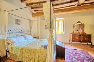 a bedroom with a canopy bed and a dresser at Villa Poggio Conca by PosarelliVillas in Incisa in Valdarno +25 photos