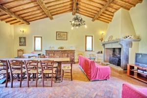 a dining room with a table and a fireplace at Villa Poggio Conca by PosarelliVillas in Incisa in Valdarno