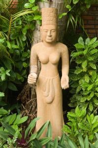 une statue d'une personne debout dans un jardin dans l'établissement Cham Villas Resort, à Mui Ne