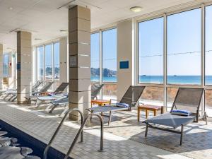a lounge area with chairs, tables, chairs and umbrellas at L’Horizon Beach Hotel & Spa in St. Brelade
