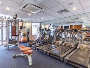 a gym with treadmills and machines in a room at L’Horizon Beach Hotel & Spa in St Brelade