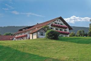ein großes Gebäude auf einem Hügel mit einem Grasfeld in der Unterkunft Wild-Berghof Buchet in Bernried
