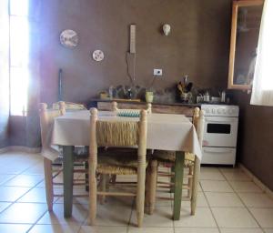 a kitchen with a table with chairs and a stove at Verde Niña Casas Serranas in Cortaderas