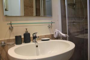 a white sink in a bathroom with a shower at Dépendance La Casetta in Castellammare di Stabia +37 photos