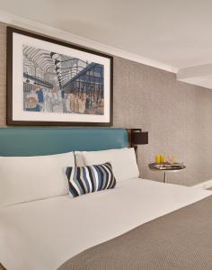 a bedroom with a white bed and a picture on the wall at Citadines Barbican London in London