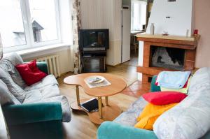 ein Wohnzimmer mit 2 Sofas, einem Tisch und einem Kamin in der Unterkunft Beautiful & Big Family Villa in Klaipėda