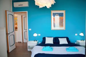una camera blu con un letto e una parete blu di Sea, casa sul mare a Termoli