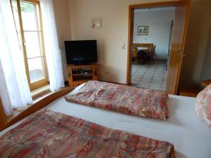 a bedroom with a bed and a flat screen tv at Ferienwohnung Am Alten Berg in Ochsenfurt
