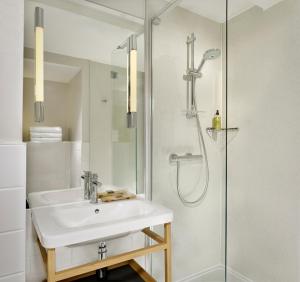 a bathroom with a sink and a shower at Citadines Barbican London in London
