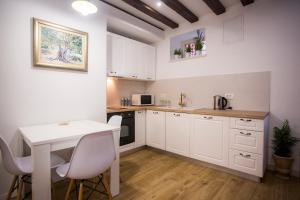 a kitchen with white cabinets and a table and chairs at Studio apartman Ana in Split