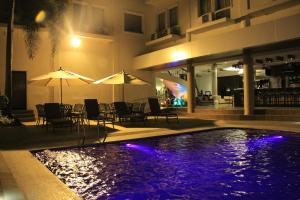 a swimming pool with chairs and umbrellas next to a building at Savannah Resort Hotel in Angeles