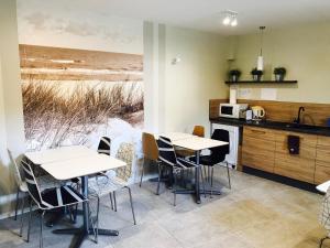 two tables and chairs in a kitchen with a view of the beach at Willa Horn in Władysławowo