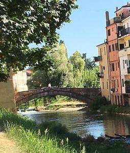 eine Brücke über einen Fluss in einer Stadt in der Unterkunft mansardina artista in Padua