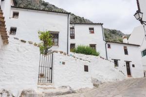a white building with a gate on the side of it at Conjunto Rural Casa Victoria in Villaluenga del Rosario