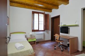 a bedroom with a bed and a desk with a computer at Residence Cavazza in Bologna