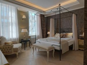 a bedroom with a four poster bed and a chair at Relais Le Chevalier in Rīga