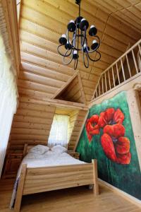a bedroom with a bed and a painting of flowers at Willa Na Werlasowym Żbyrze in Werlas