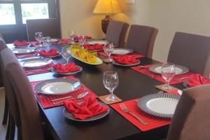 une table noire avec des serviettes rouges, des assiettes et des verres à vin dans l'établissement Villa de Roshe, à Nuwara Eliya