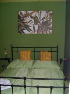 a green bedroom with a bed with two pillows at Casa Allorello in Laureana Cilento
