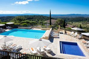 a villa with a swimming pool and a patio with umbrellas at La Bastide de Sanilhac in Sanilhac