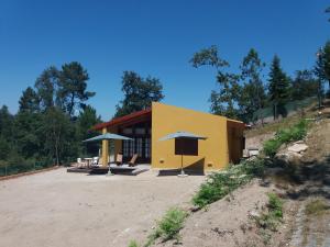 ein gelbes Gebäude mit Sonnenschirmen davor in der Unterkunft Casas de Canavezes in Marco de Canavezes