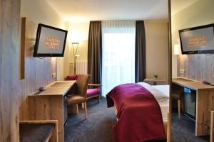 ein Hotelzimmer mit einem Bett und einem Schreibtisch in der Unterkunft Gästehaus am Kurpark in Schliersee