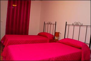 コニル・デ・ラ・フロンテーラにあるApartamento Duplex en Conilの赤いシーツが備わるドミトリールームのベッド2台