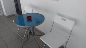 een blauwe tafel met een vaas erop naast een stoel bij Vivenda Valverde in Nazaré