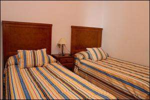 コニル・デ・ラ・フロンテーラにあるApartamento Loyolaのベッド2台が隣同士に設置された部屋です。