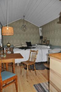 Schlafzimmer mit einem Bett, einem Tisch und einem Stuhl in der Unterkunft Håkesgård Bed&Garden in Veddige