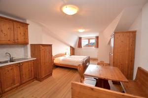 a kitchen with a bed and a table in a room at Aurturist Miramonti S Candido in San Candido