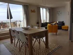 een eettafel en stoelen in de woonkamer bij Le 1003 in Nieuwpoort