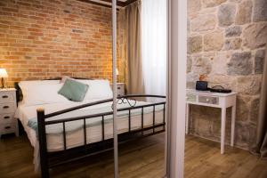 a bedroom with a bed and a brick wall at Studio apartman Ana in Split