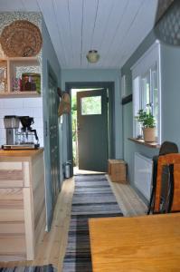 a kitchen with a green door and a wooden floor at Håkesgård Bed&Garden in Veddige