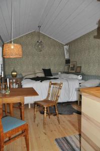 a bedroom with a bed and a table and a chair at Håkesgård Bed&Garden in Veddige